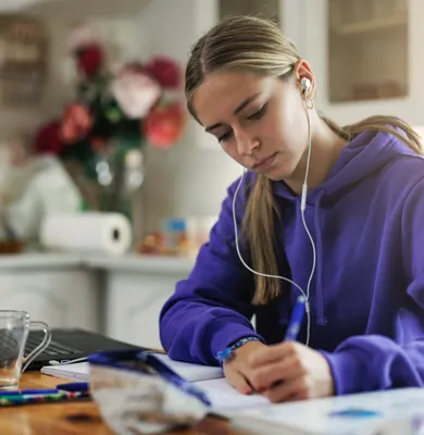 Teen student improving focus and organization skills while doing homework with executive function coaching support