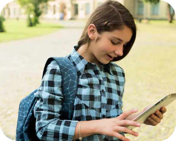 Teen girl studying with a digital device outdoors