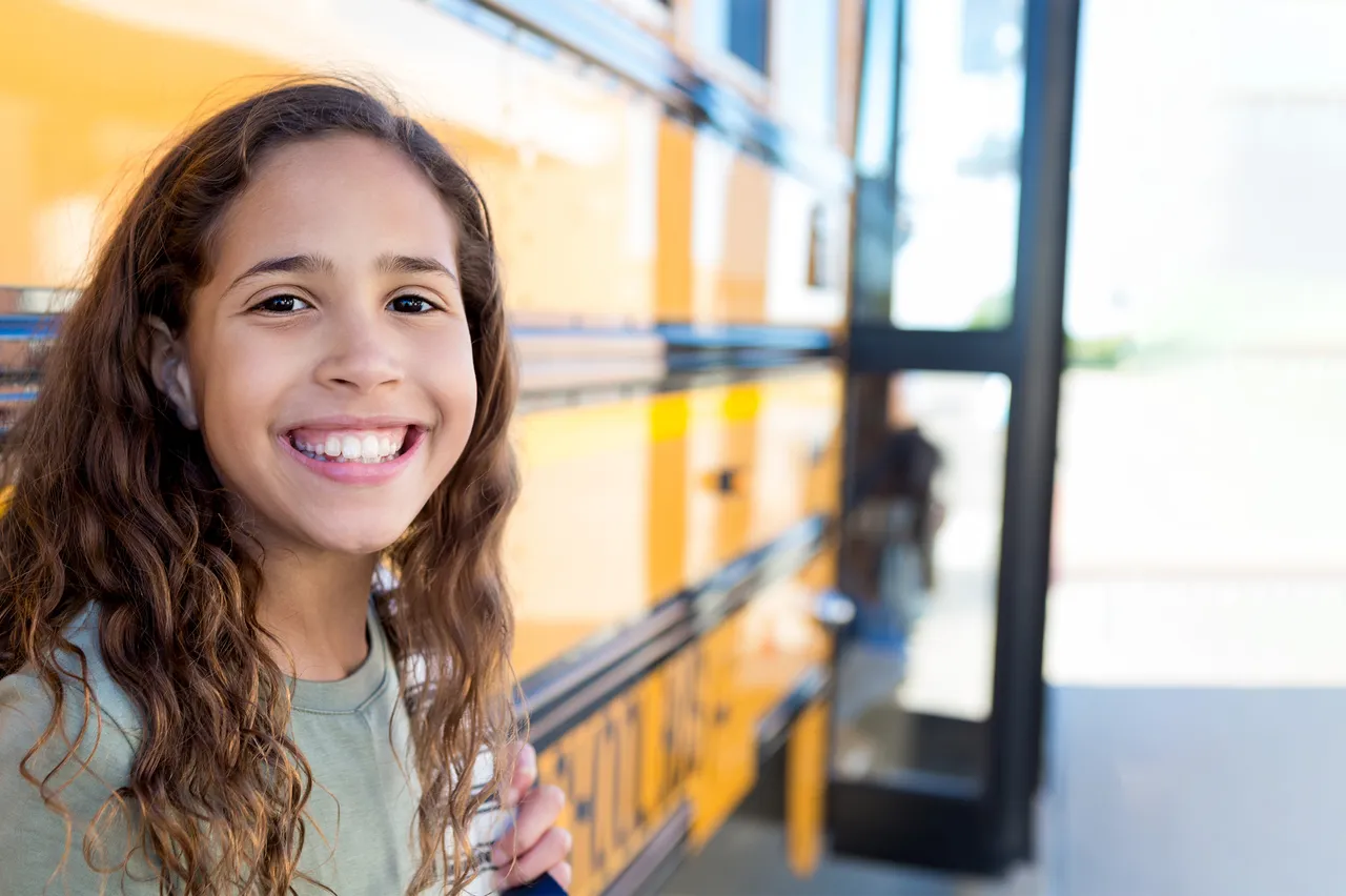 Happy teen with backpack ready for school success after learning executive functioning and study skills through coaching